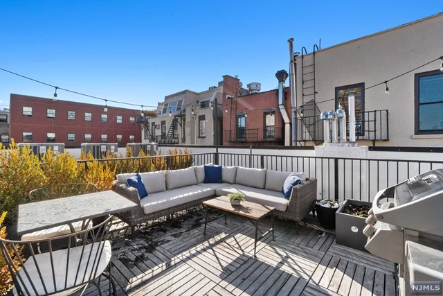 a roof deck with couches and potted plants with sky view