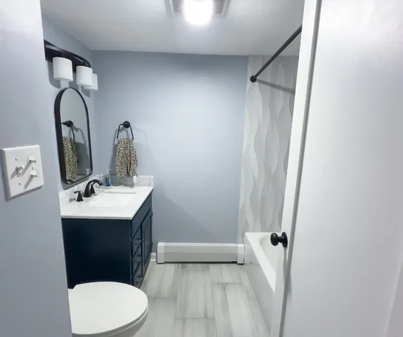 a bathroom with a sink mirror vanity and toilet