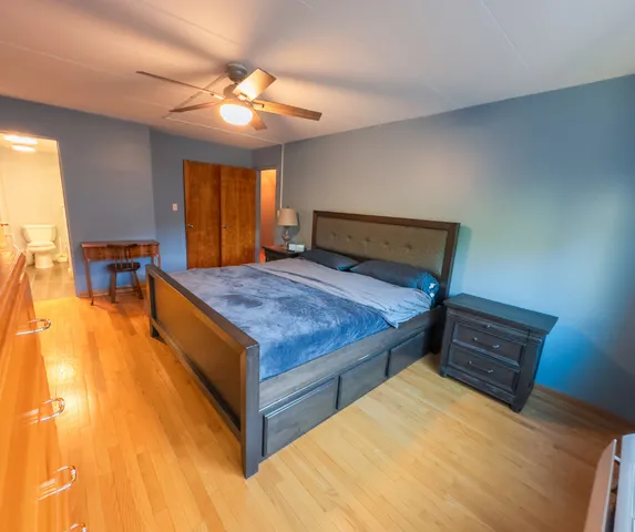 a bed sitting in a spacious bedroom next to a window
