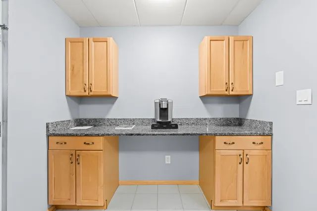 a kitchen with granite countertop cabinets stainless steel appliances a sink and a window