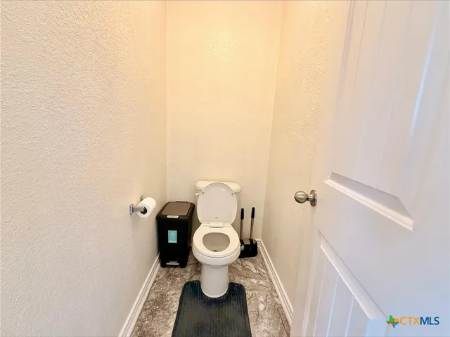 a white toilet sitting next to a small bathroom