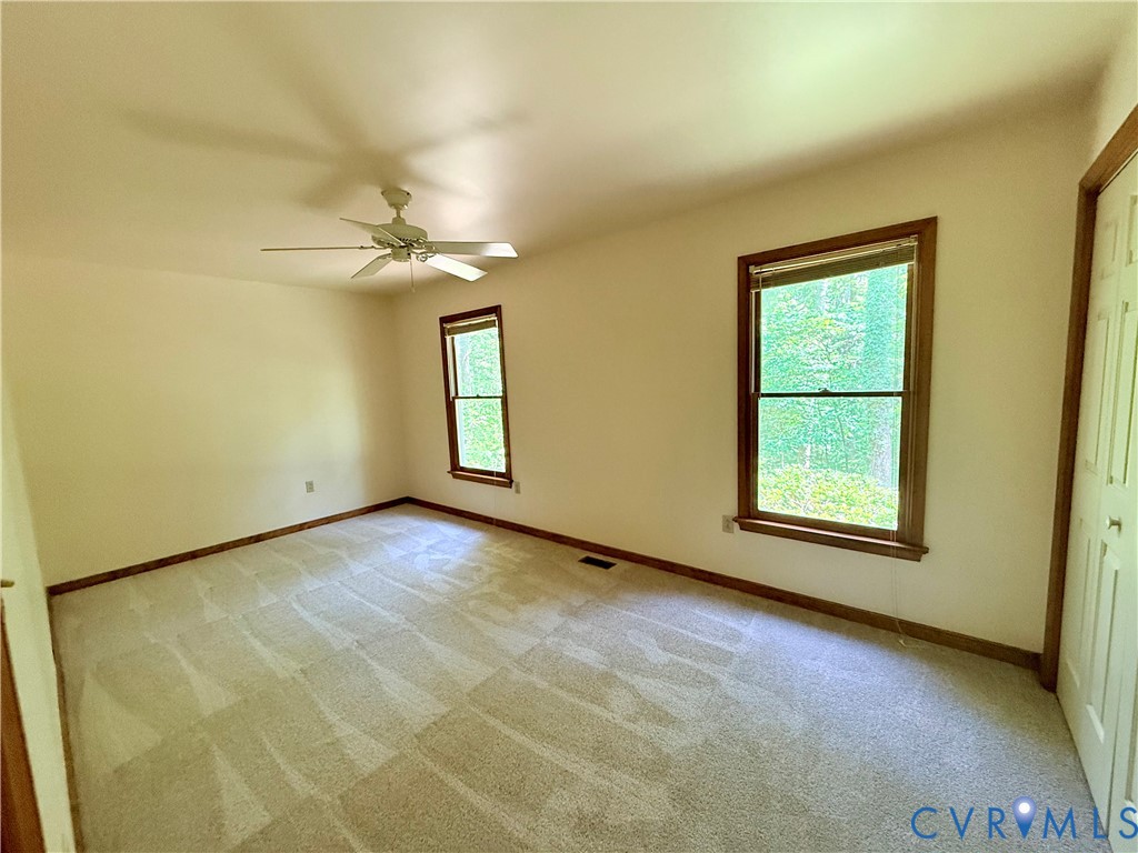 2590 Davis Mill Road Goochland, VA 23063 - Photo 4 of 33 an empty room with windows and chandelier fan