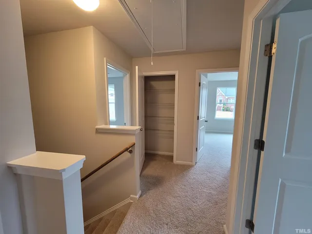 a view of hallway with bathroom and a sink