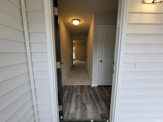 a view of a hallway with wooden floor and staircase