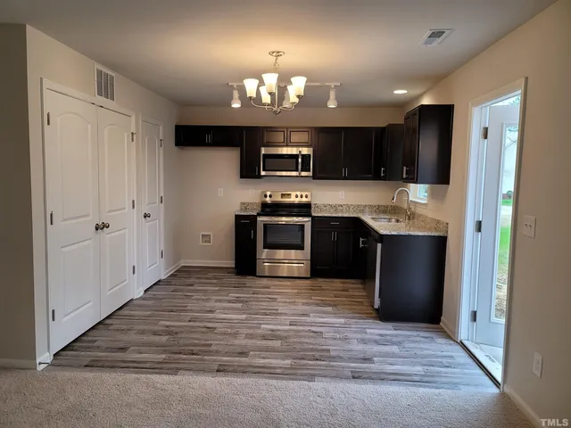 a large kitchen with a sink and stainless steel appliances