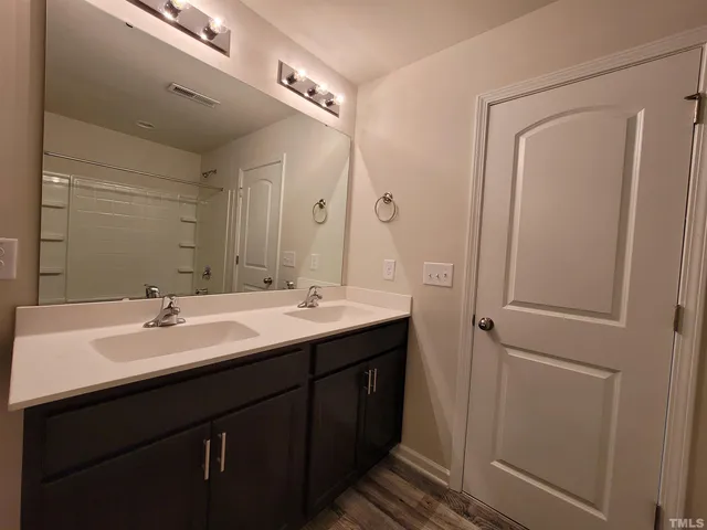 a bathroom with a double vanity sink and mirror