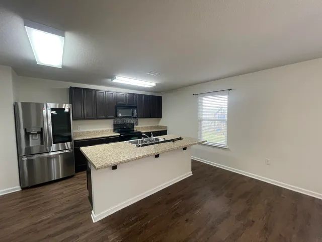 a large kitchen with stainless steel appliances a large counter top and a stove