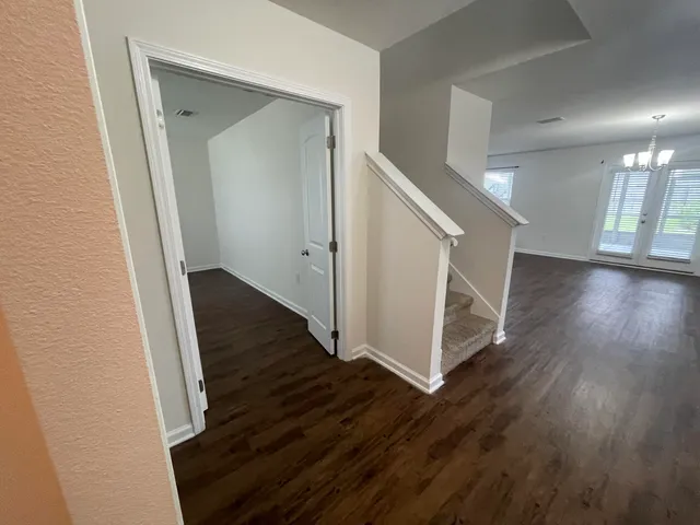 a view of a hallway with wooden floor and staircase