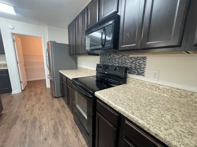 a kitchen with granite countertop stainless steel appliances and wooden cabinets