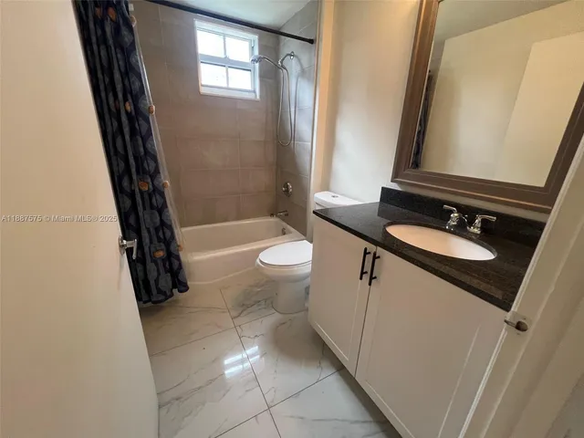 a bathroom with a sink a toilet a tub and shower