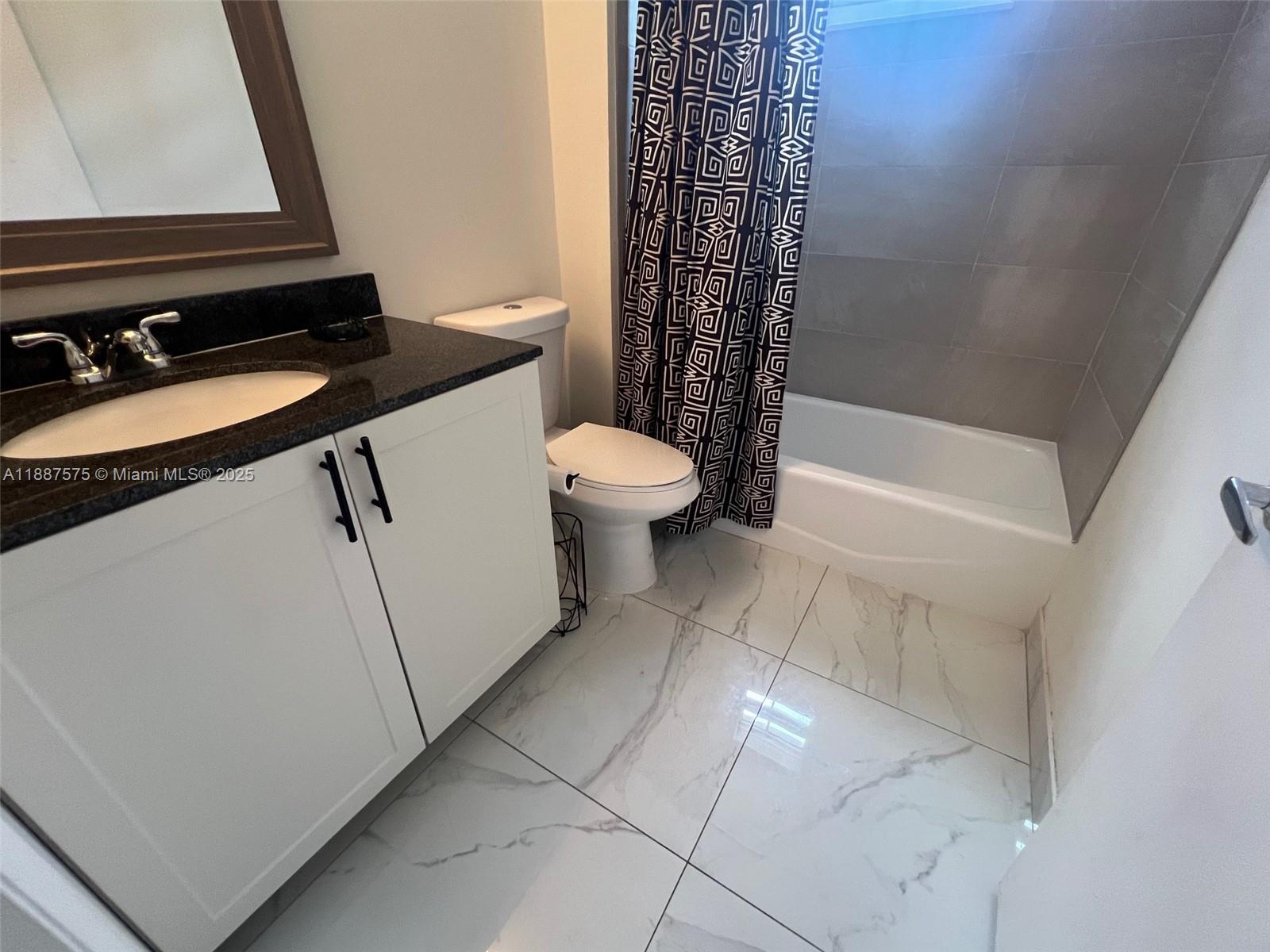 185 Southeast 14th Terrace, Unit 910 Miami, FL 33131 - Photo 10 of 12 a bathroom with a granite countertop sink toilet and shower