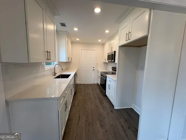 a kitchen with refrigerator and cabinets