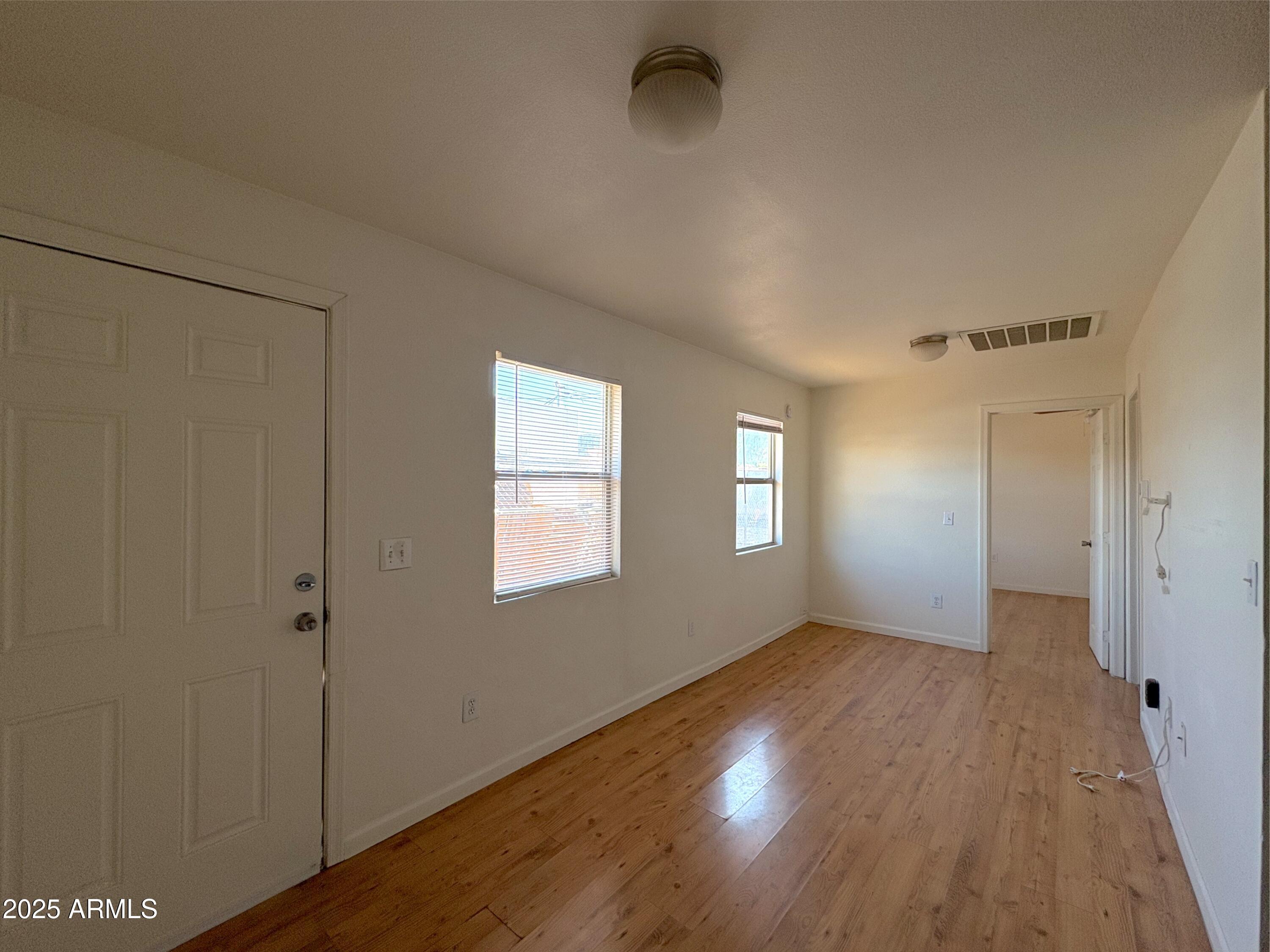 425 North 18th Drive, Unit 3 Phoenix, AZ 85007 - Photo 8 of 10 an empty room with wooden floor and windows