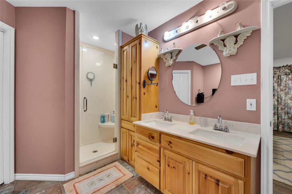 839 Walker Creek Road Ennis, TX 75119 - Photo 25 of 40 a spacious bathroom with a double vanity sink mirror double and shower
