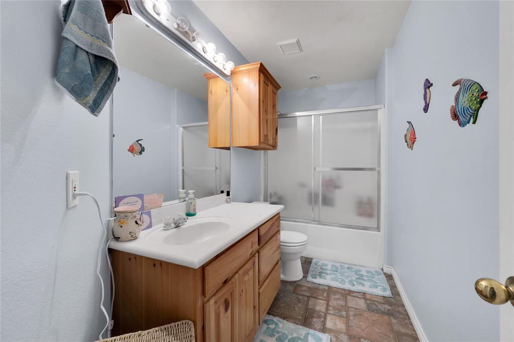 839 Walker Creek Road Ennis, TX 75119 - Photo 30 of 40 a bathroom with a sink toilet a mirror and bathtub