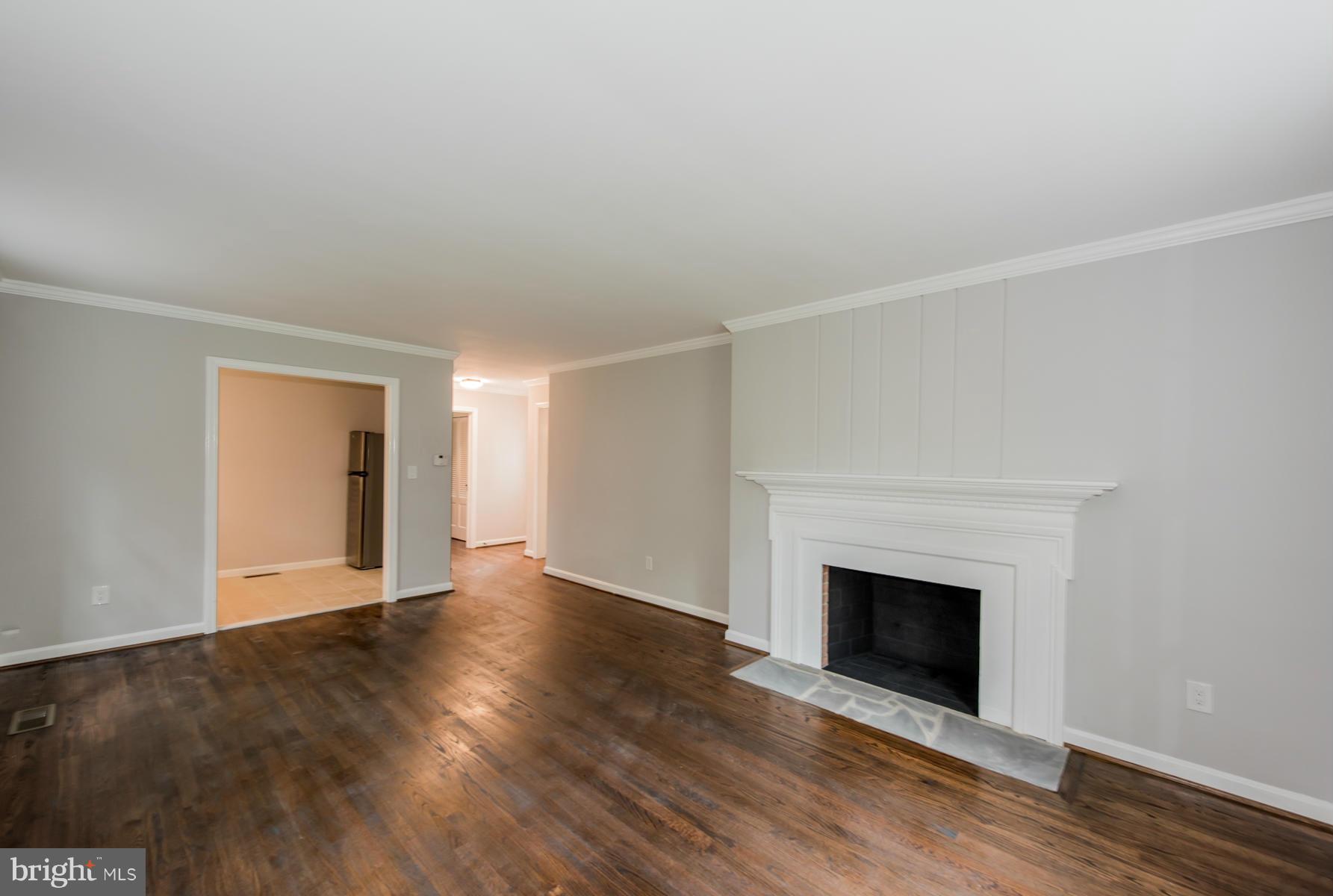 9105 Waycross Road Ellicott City, MD 21042 - Photo 20 of 27 a view of an empty room with wooden floor fireplace and a window