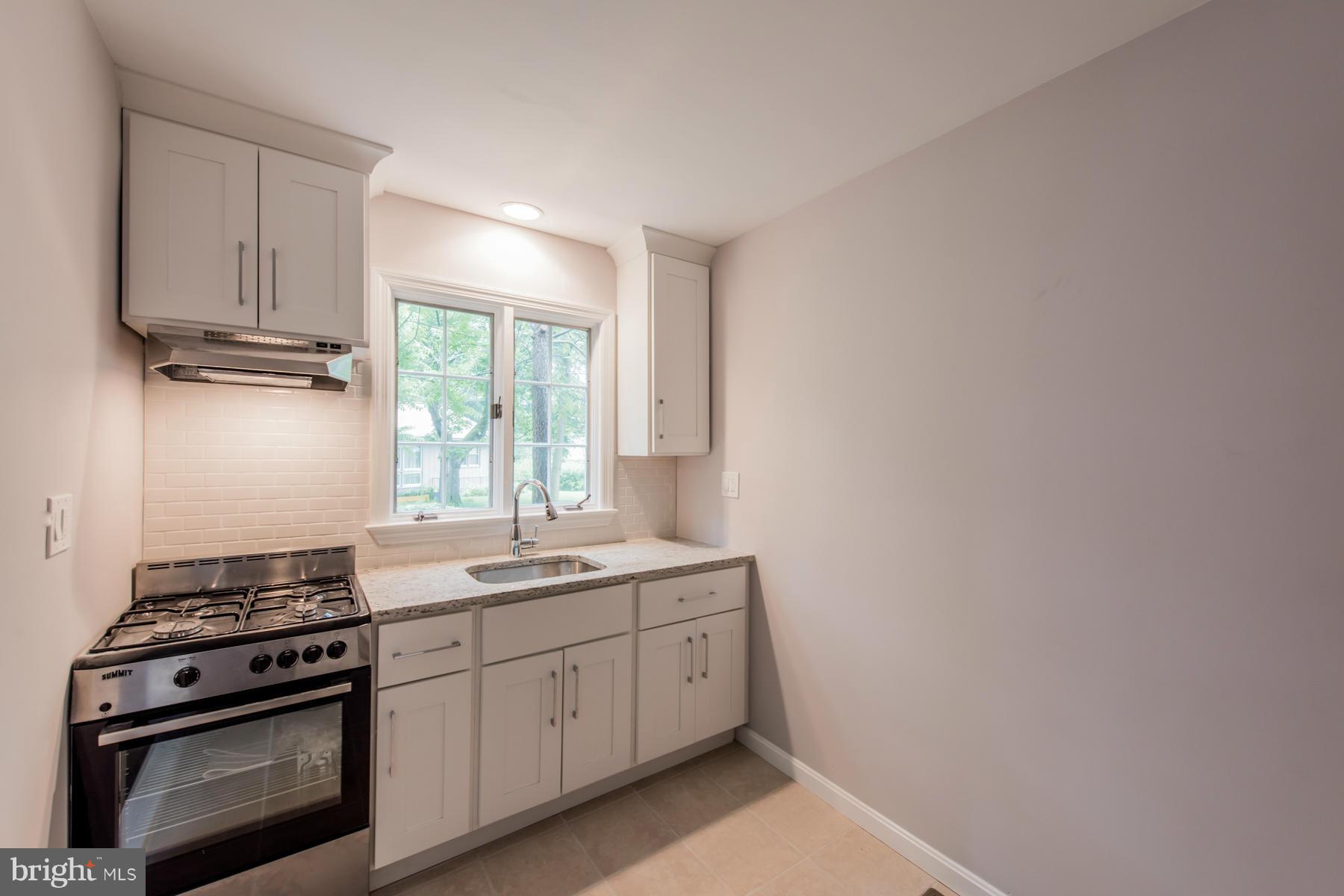 9105 Waycross Road Ellicott City, MD 21042 - Photo 21 of 27 a kitchen with a sink stove and cabinets