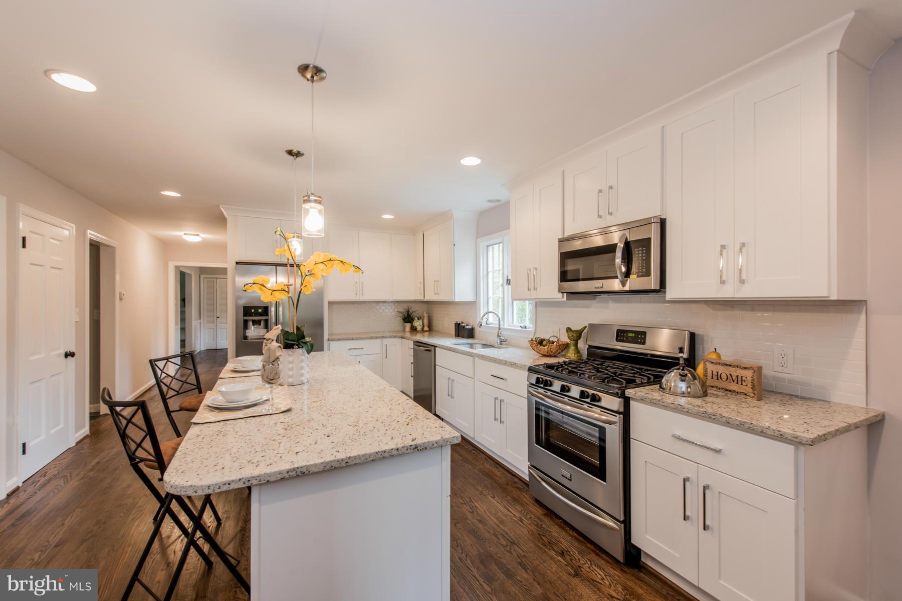 9105 Waycross Road Ellicott City, MD 21042 - Photo 5 of 27 a kitchen with a sink a kitchen island and stainless steel appliances