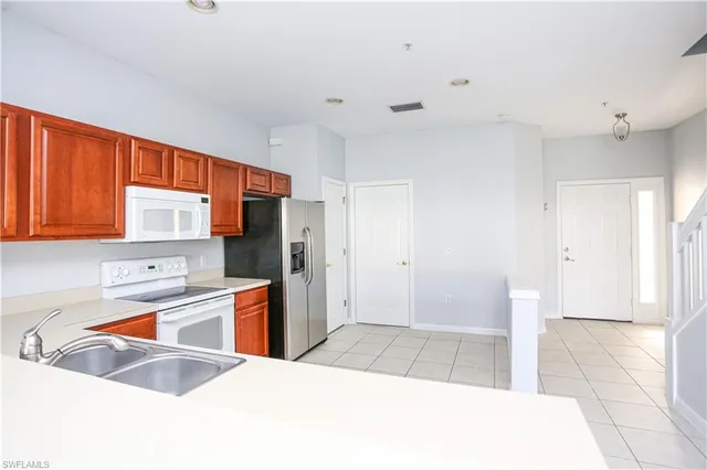 a kitchen with stainless steel appliances granite countertop a refrigerator and a sink