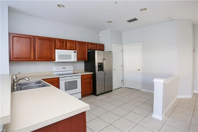 a kitchen with a refrigerator sink and cabinets