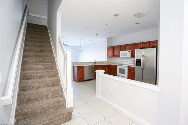 a view of a kitchen with a sink and refrigerator