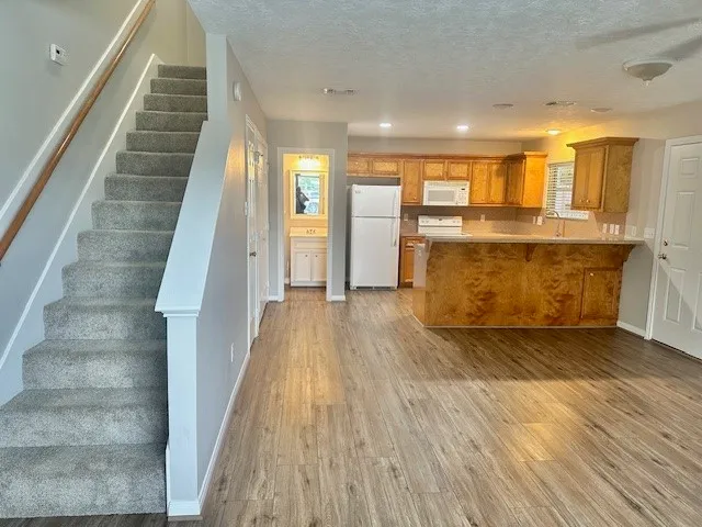 a view of a living room with wooden floor and staircase