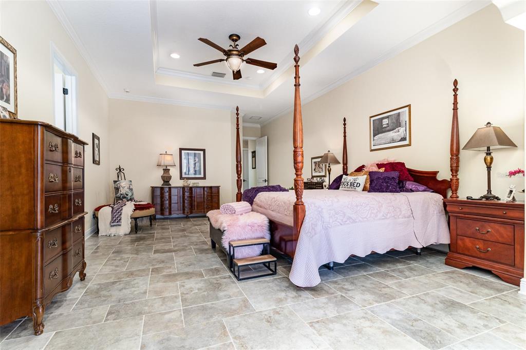 404 Long And Winding Road Howey-in-the-Hills, FL 34737 - Photo 19 of 48 a spacious bedroom with a bed and ceiling fan
