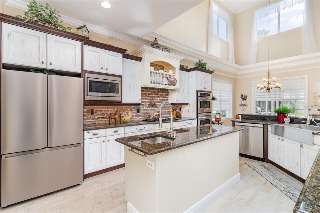 404 Long And Winding Road Howey-in-the-Hills, FL 34737 - Photo 10 of 48 a kitchen with stainless steel appliances a refrigerator sink and cabinets