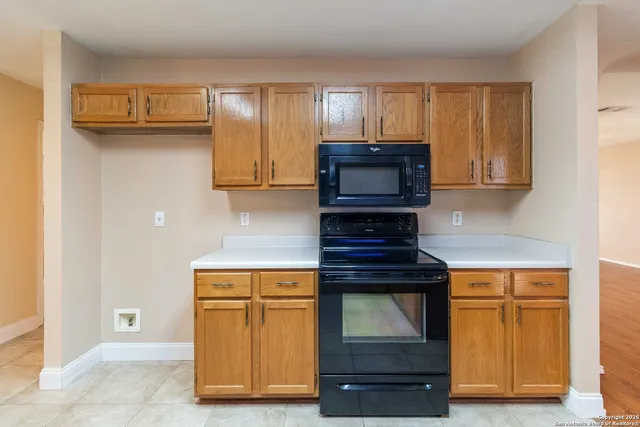 a kitchen with wooden cabinets and a stove top oven