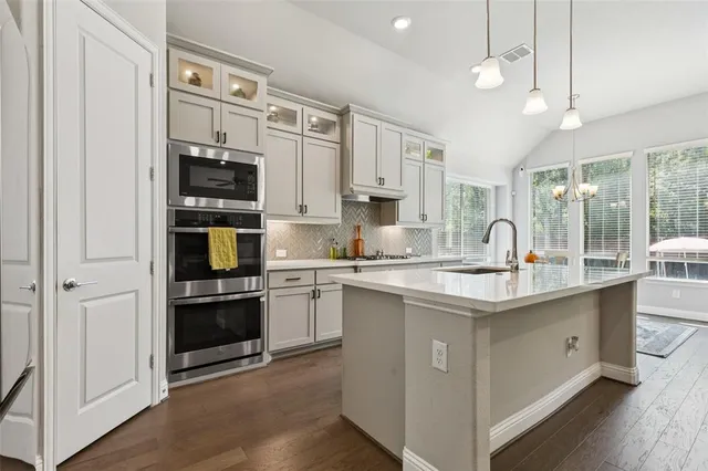 a kitchen with a sink stove and cabinets