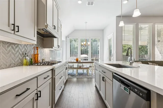 a kitchen with stainless steel appliances granite countertop a sink a stove and a refrigerator