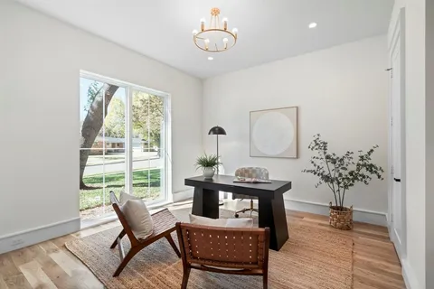 a dining room with furniture potted plants and wooden floor