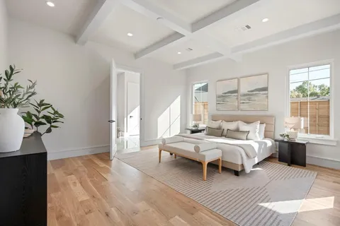 a bedroom with a large bed and a potted plant