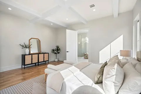 a bedroom with a large bed and a chandelier