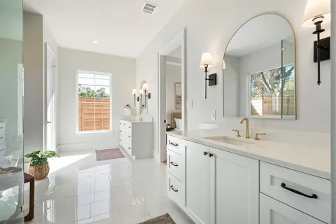 a spacious bathroom with a granite countertop sink mirror and a bathtub