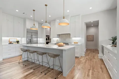 a kitchen with a sink a counter space appliances and cabinets
