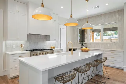 a kitchen with a table a sink cabinets and wooden floor