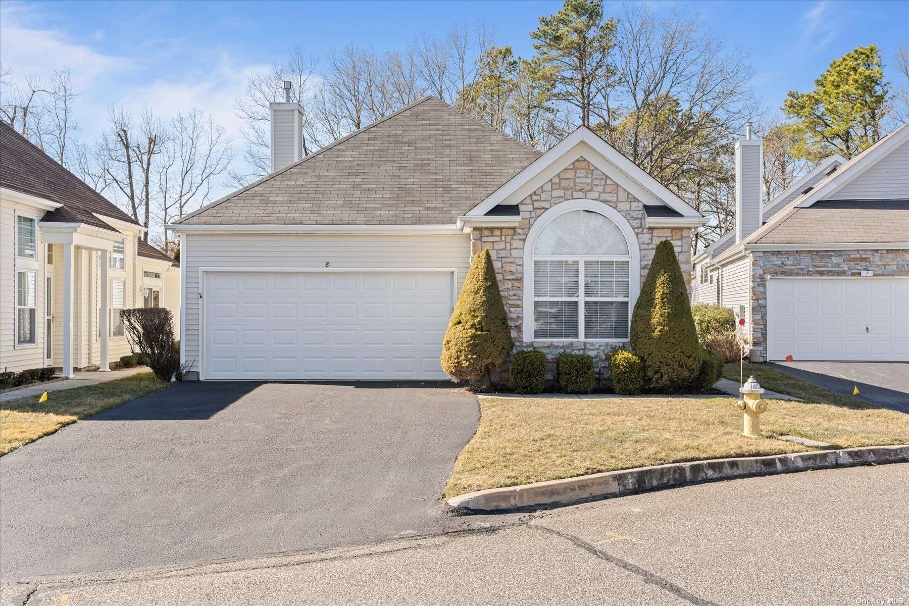 8 Sagaponack Court, Unit 8 Ridge, NY 11961 - Photo 1 of 1 a view of a white house with a large tree and wooden fence