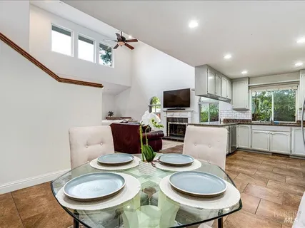 a living room with furniture a flat screen tv and kitchen view