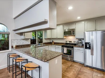 a kitchen with kitchen island a large counter top space appliances and cabinets