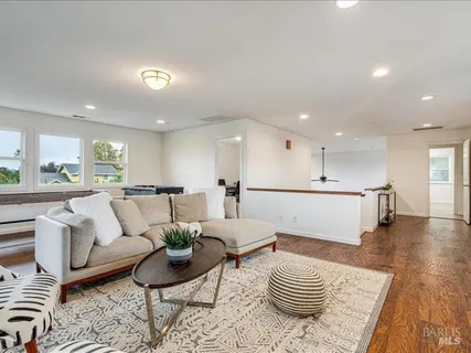 a living room with furniture and a view of kitchen