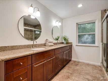a bathroom with a double vanity sink and a mirror