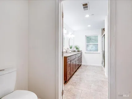 a bathroom with a sink a toilet and a window