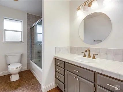 a bathroom with a toilet a sink and mirror