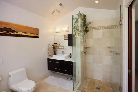 a bathroom with a sink a toilet and shower