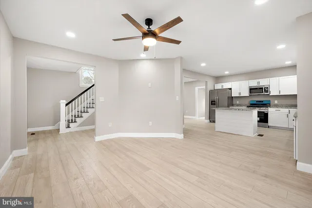 a kitchen with stainless steel appliances granite countertop a refrigerator sink and white cabinets