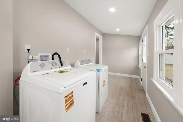 a view of a white house with a big yard and large trees