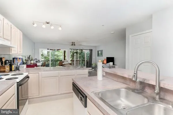 a kitchen with granite countertop a sink and white cabinets next to a window