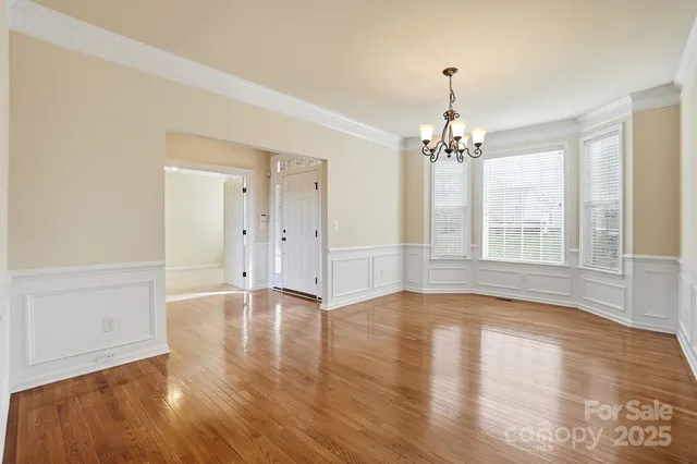 a view of a room with a ceiling fan and carpet