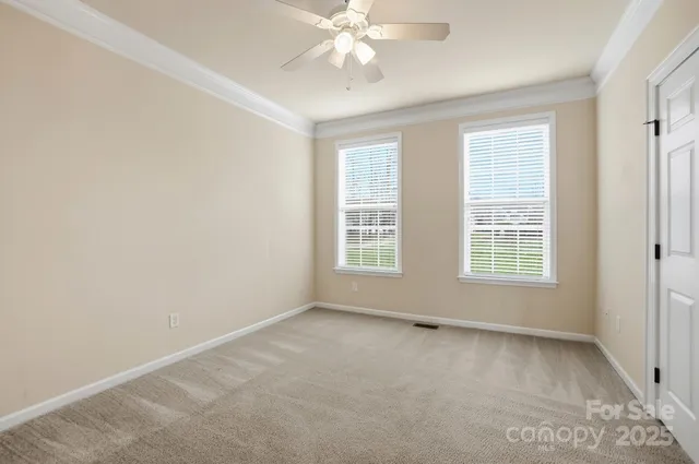 an empty room with a window and a ceiling fan